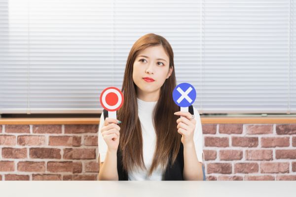 ○×カードを持つ女性